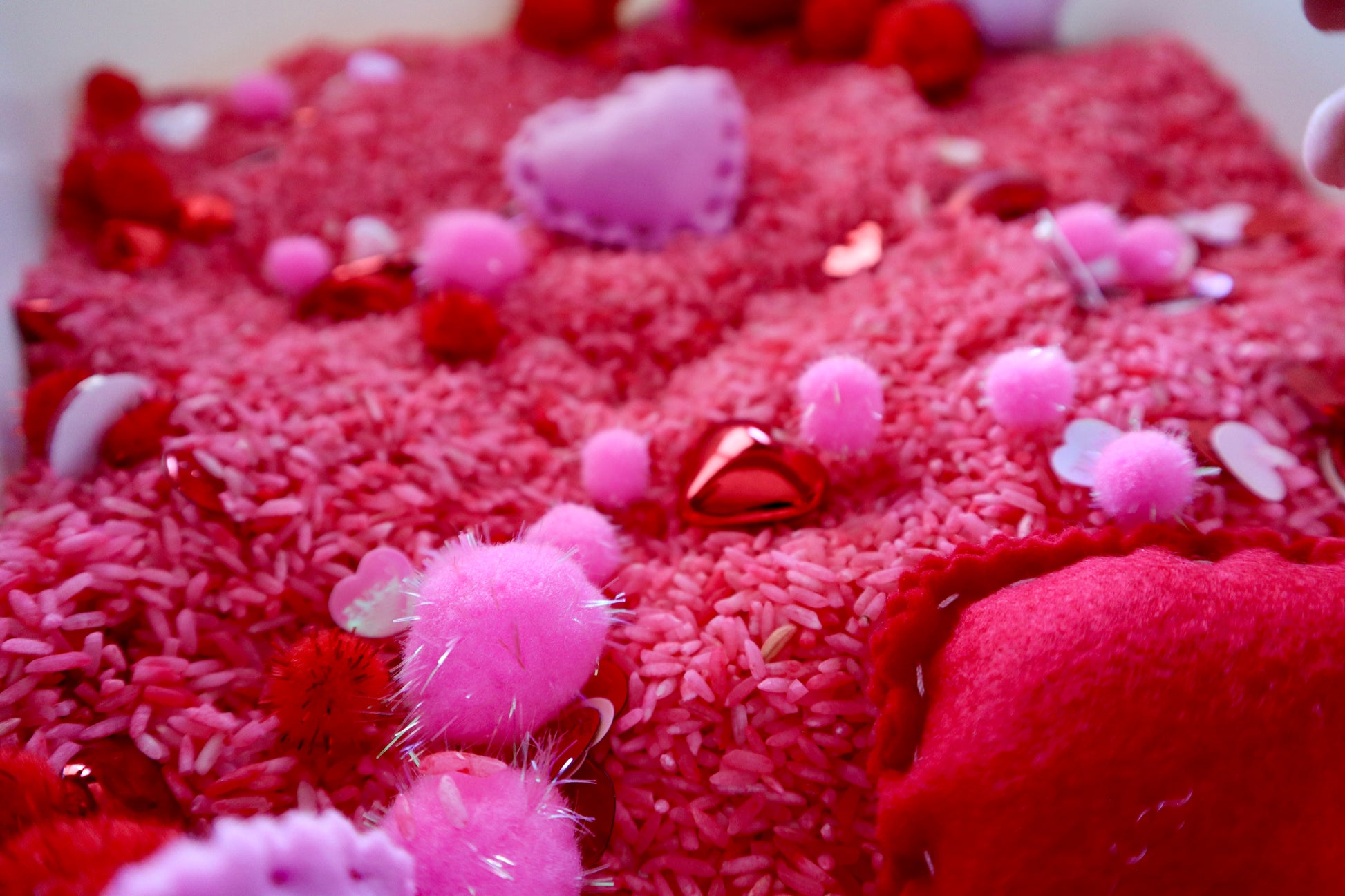 Close-up of a textured red surface with pink and white decorative elements