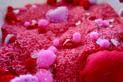 Close-up of a textured red surface with pink and white decorative elements
