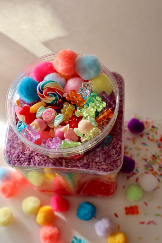 Clear container filled with colorful candy-like objects on a light background